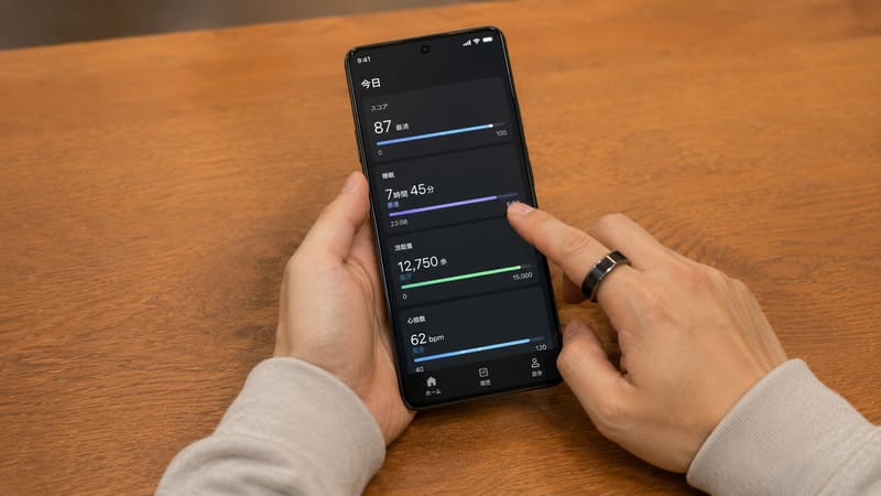 スマートリングを着けてスマホで健康データを確認する様子